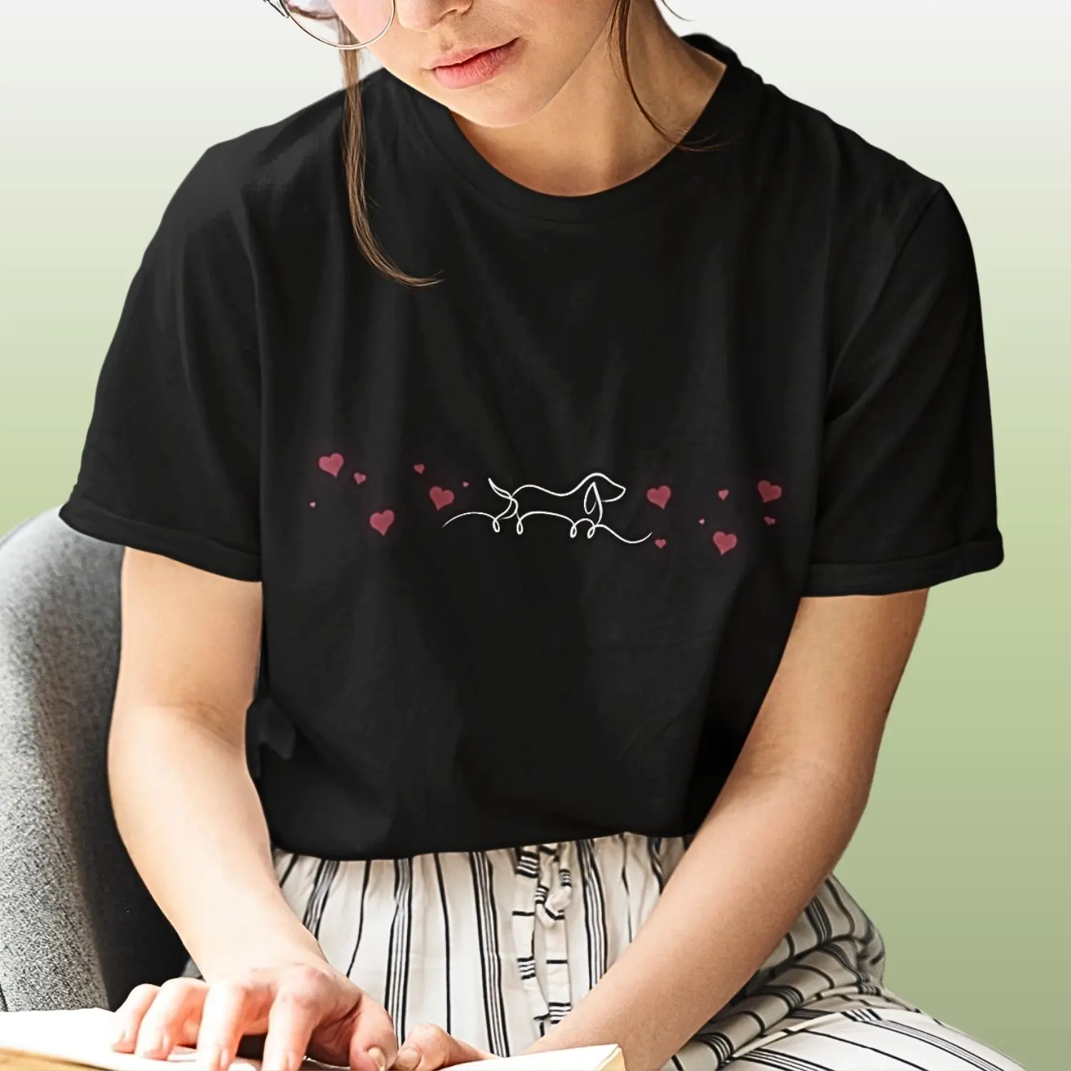 Camiseta com uma silhueta de cachorro ao centro e corações nas laterais.