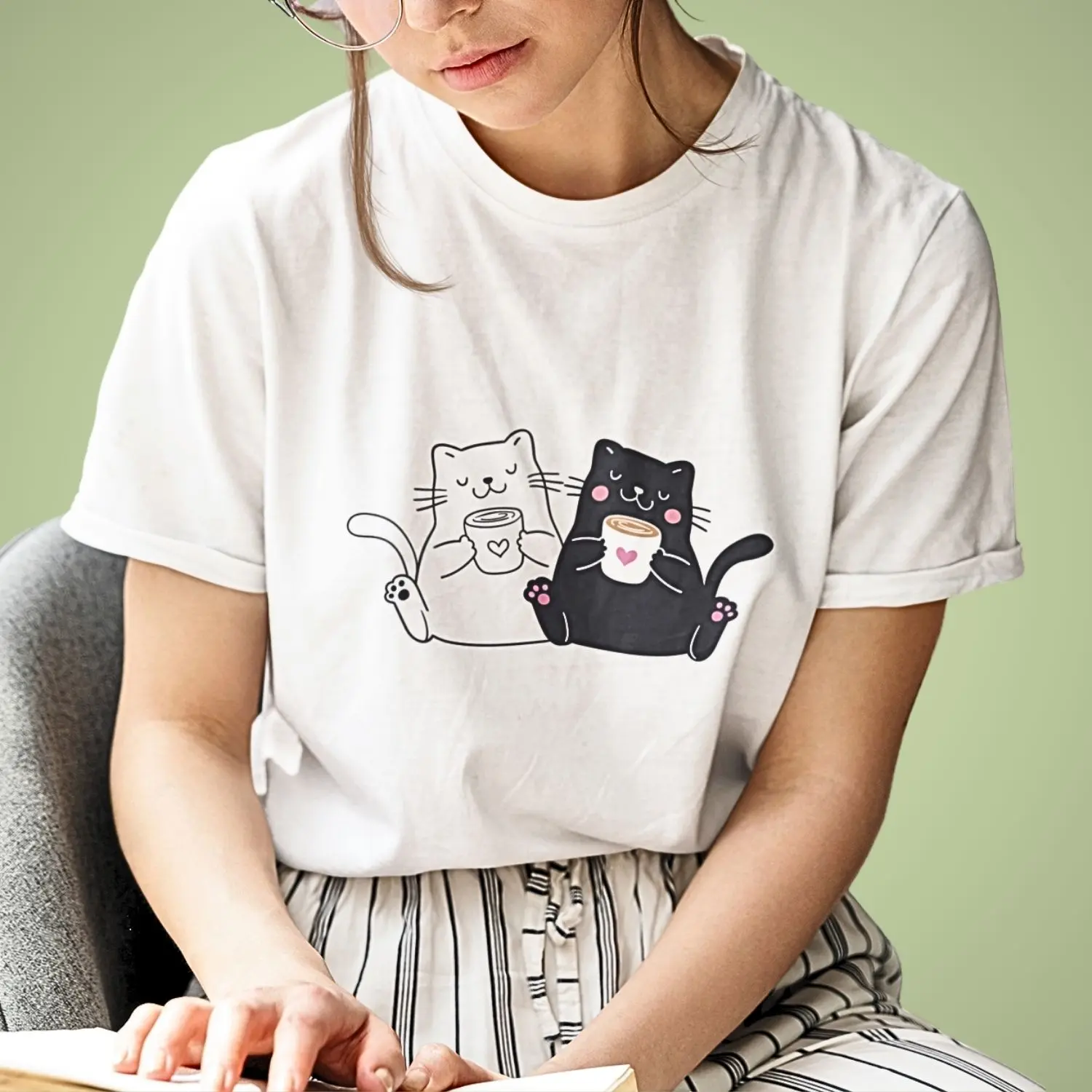Camiseta com desenho de um gato branco e um preto bebendo café