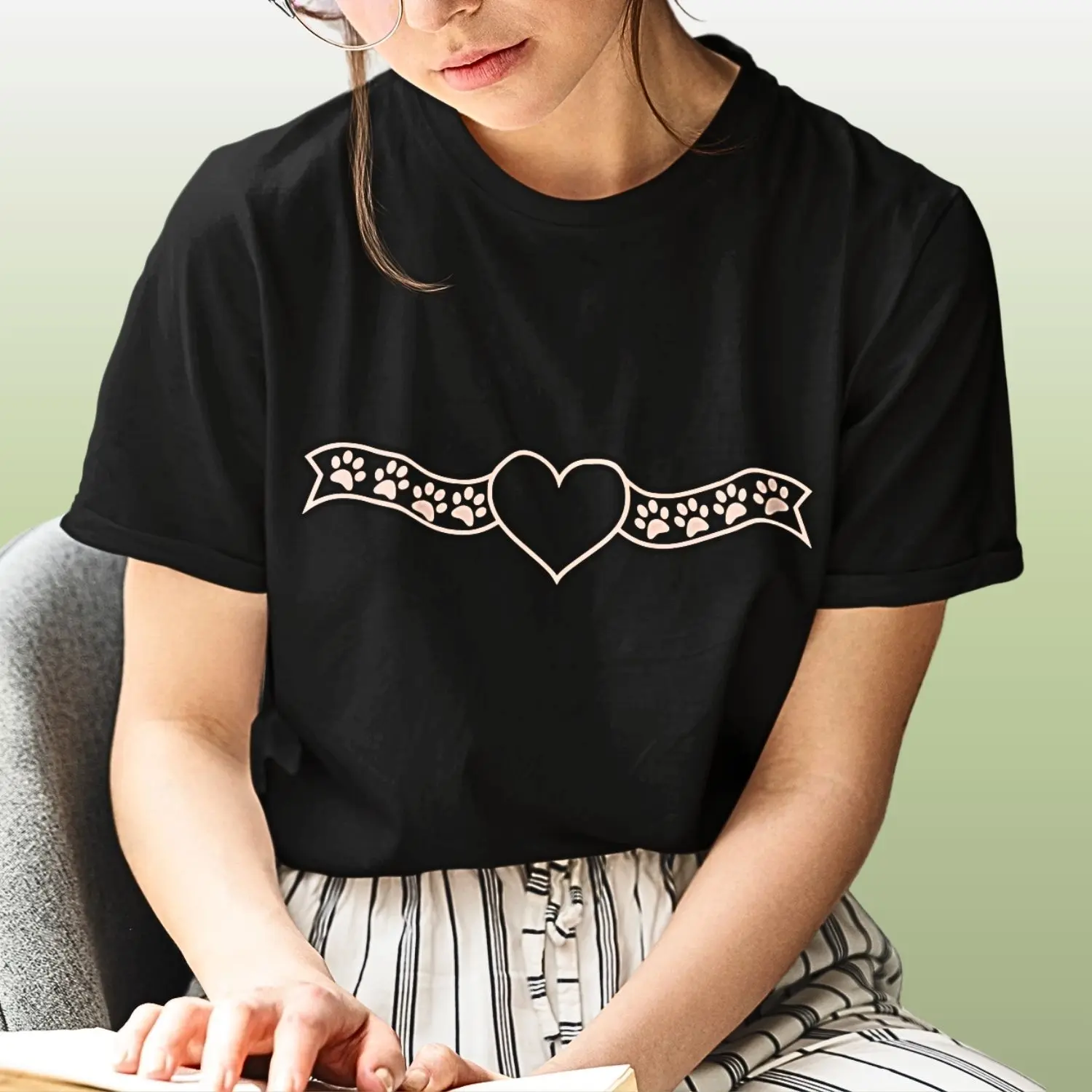 camiseta com desenho central de um coração e nas laterais uma fita com patinhas